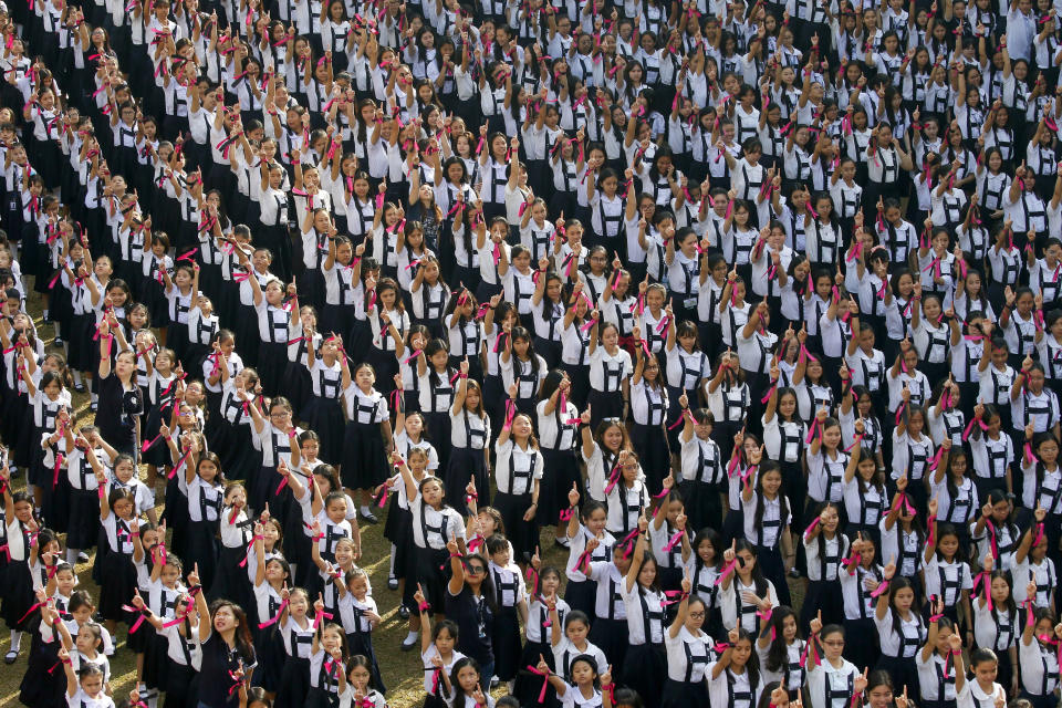 In this Thursday, Feb. 14, 2019, file photo, thousands of students and faculty from the Catholic-run St. Scholastica's College, flash No. 1 signs at the end of a mass dance, dubbed "One Billion Rising" at their campus on the 7th anniversary of the global movement to help eradicate violence against women and children on Valentine's Day in Manila, Philippines. The annual mass dancing is being held every Valentine's Day. (AP Photo/Bullit Marquez, File)