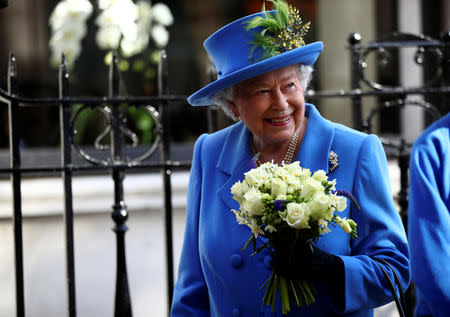 Britain's Queen Elizabeth receives a bouquet of flowers as she visits Watergate House to mark the centenary of the GCHQ (Government Communications Head Quarters) in London, Britain, February 14, 2019. REUTERS/Hannah McKay/Pool