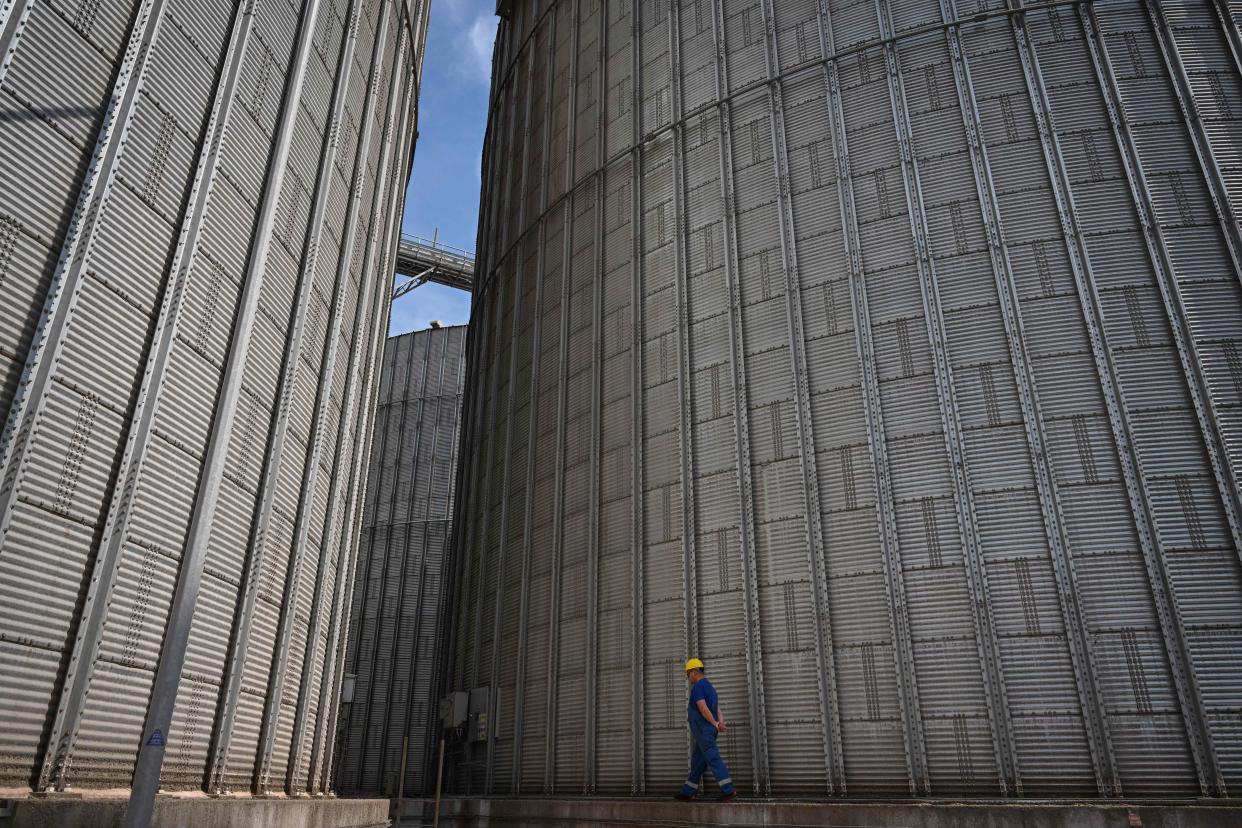 A worker pass by a grain silo at 