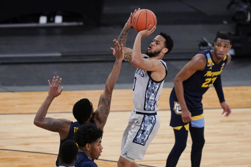 Georgetown's Jahvon Blair, center, shoots over Marquette's Symir Torrence as Jamal Cain, right, watches during the second half of an NCAA college basketball game in the Big East conference tournament Wednesday, March 10, 2021, in New York. (AP Photo/Frank Franklin II)