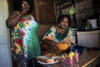 <p>Grace, a resident of Khayelitsha, and her friend Angel, eating a meat dish and drinking a fruit-flavored drink with a high sugar content. When asked if she consumes fruit in her daily diet, she answers, “Yes, I drink Coke and juice.” In South Africa, approximately two-thirds of the population are overweight and women are affected more than men: 69.3 per cent of South African women have unhealthy levels of body fat and more than four in 10 are clinically obese. (Photograph by Silvia Landi) </p>