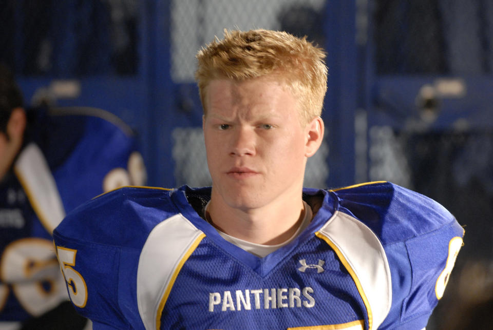 Jesse wearing a football uniform with the word "Panthers" across the chest, stands in a locker room