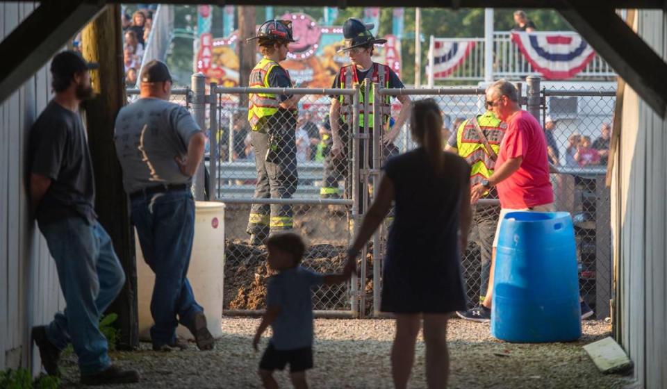People walk under the grand stands on their way to watch the demolition derby at the Platte County Fair, Thursday, July 22, 2021, in Tracy, Missouri.