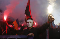 Members of the nationalist movements light flares during a rally marking Defense of the Homeland Day in center Kyiv, Ukraine, Monday, Oct. 14, 2019. Some 15,000 far-right and nationalist activists protested in the Ukrainian capital, chanting "Glory to Ukraine" and waving yellow and blue flags. President Volodymyr Zelenskiy urged participants to avoid violence and warned of potential “provocations” from those who want to stoke chaos. (AP Photo/Efrem Lukatsky)