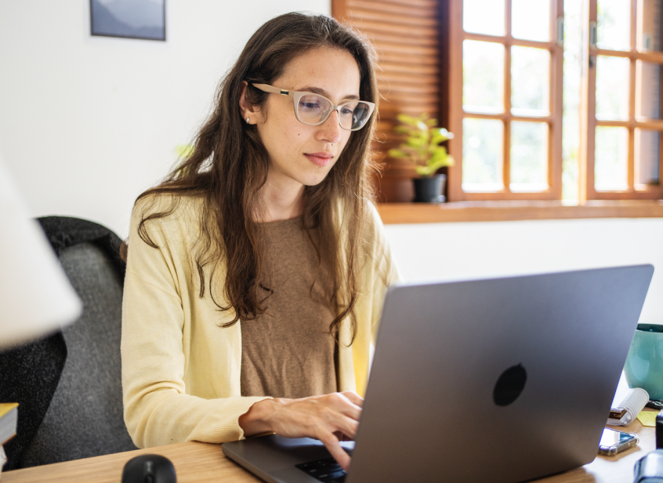 a woman sitting at a desk with a laptop