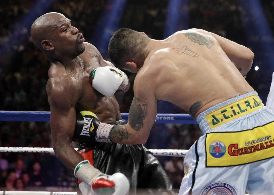 Marcos Maidana, right, from Argentina, connects with a left to the body of Floyd Mayweather Jr. in their WBC-WBA welterweight title boxing fight Saturday, May 3, 2014, in Las Vegas. (AP Photo/Isaac Brekken)