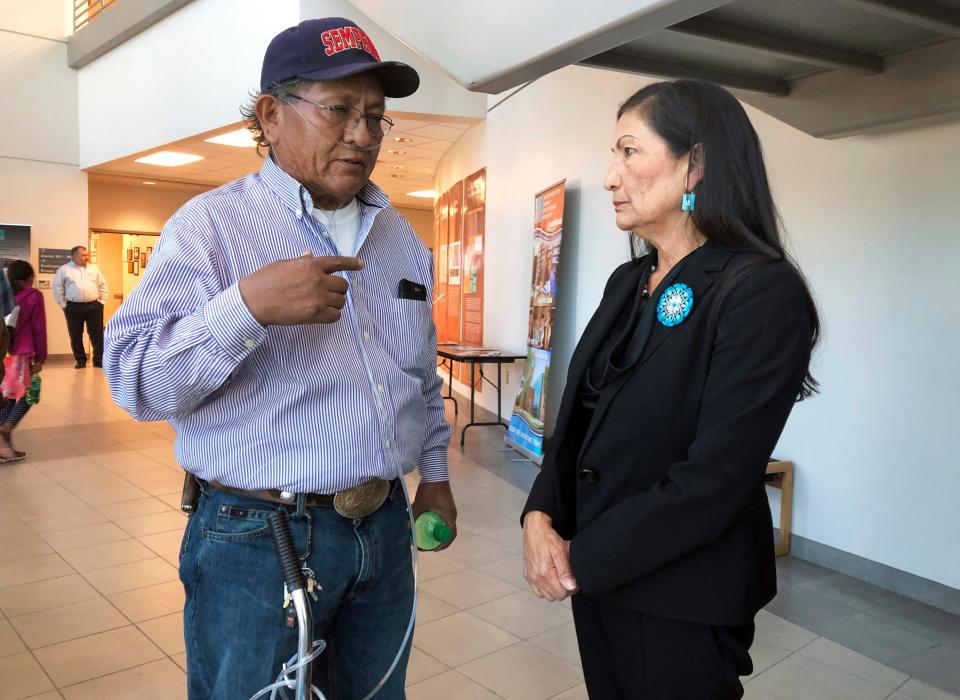 Leslie Begay, left, speaks with Rep. Deb Haaland, D-New Mexico, in a hallway outside a congressional field hearing in 2019 in Albuquerque, N.M.