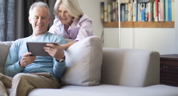 Senior couple using tablet computer at home