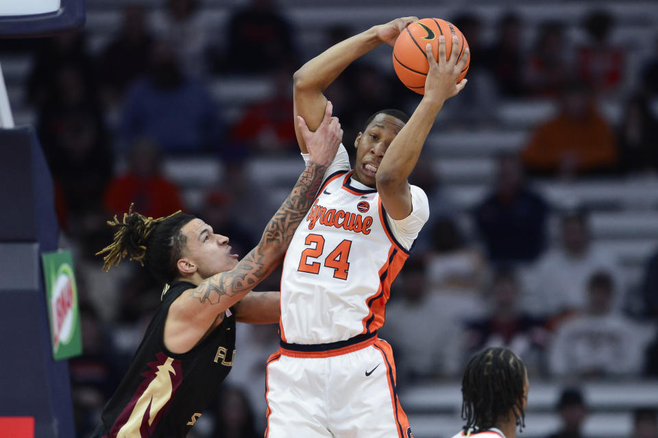 Syracuse guard Quadir Copeland, right, grabs a rebound over Florida State forward De'Ante Green during the second half of an NCAA college basketball game in Syracuse, N.Y., Tuesday, Jan. 23, 2024. (AP Photo/Adrian Kraus)