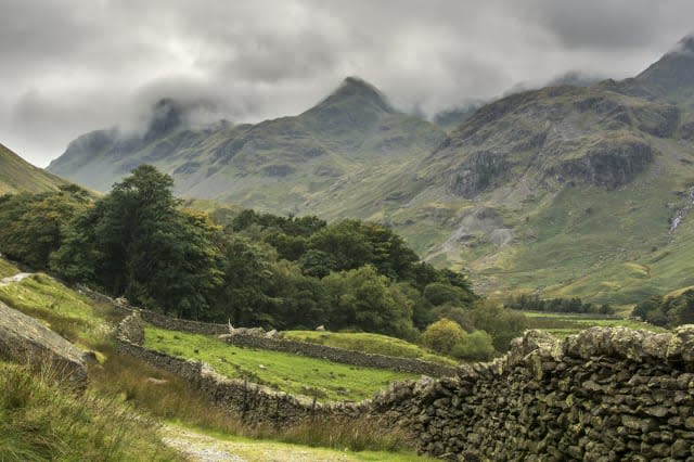 Valley in English Lake District with misty mountains and woodland.