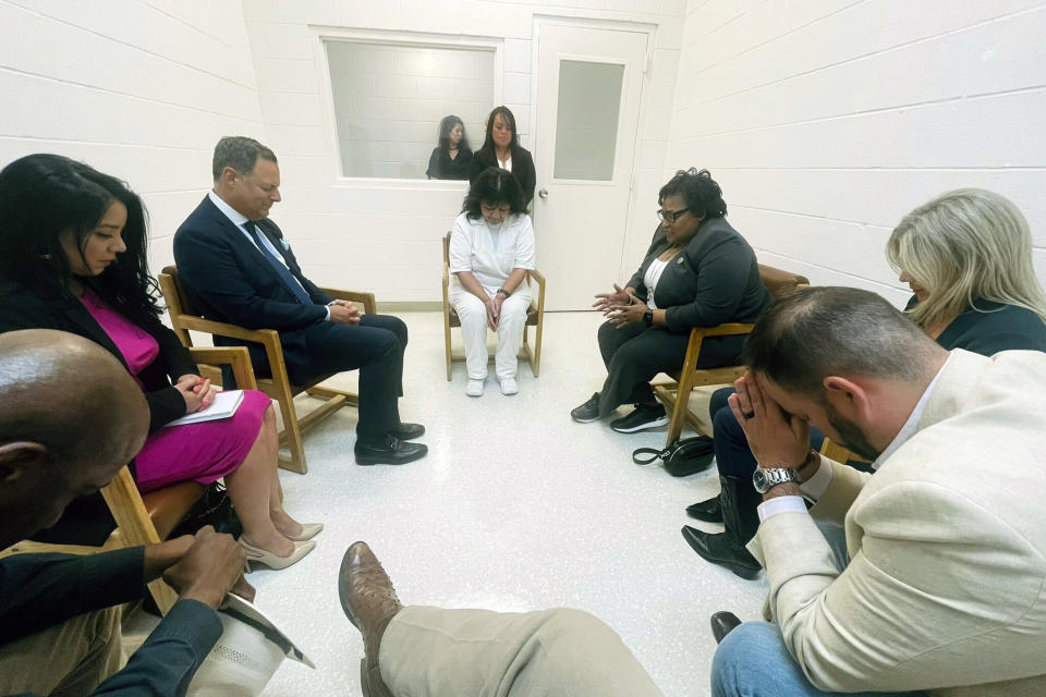 In this April 6, 2022 photo provided by Texas state Rep. Jeff Leach, Texas death row inmate Melissa Lucio, dressed in white, leads a group of seven Texas lawmakers in prayer in a room at the Mountain View Unit in Gatesville, Texas. The lawmakers visited Lucio to update her about their efforts to stop her April 27 execution. The lawmakers say they are troubled by Lucio’s case and believe her execution should be stopped as there are legitimate questions about whether she is guilty. (Texas state Rep. Jeff Leach via AP)
