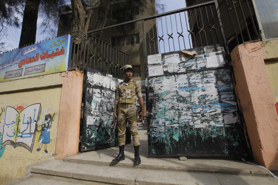 An Egyptian army soldier stands guard in front of a polling station in Cairo, Egypt, Monday, Jan. 13, 2014. The January 14-15 vote on the draft constitution will be the first real test of the post-Morsi regime. A comfortable "yes" vote and a respectable turnout would be seen as bestowing legitimacy, while undermining the Islamists' argument that Morsi remains the nation's elected president. (AP Photo/Amr Nabil)