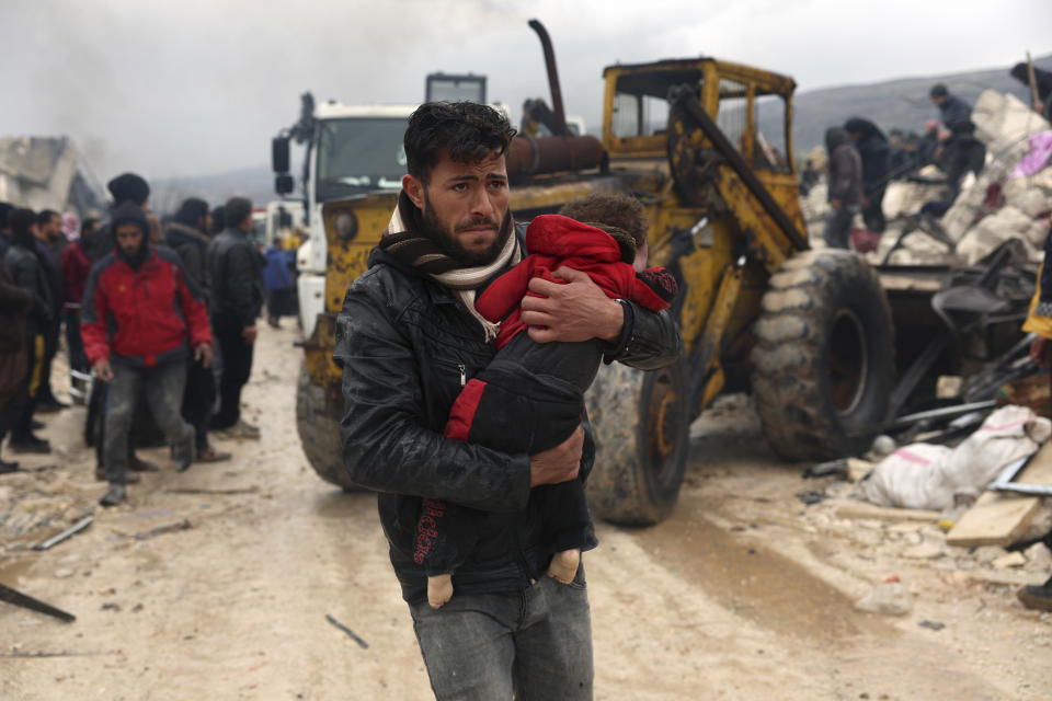 FILE - A man carries the body of an earthquake victim in the Besnia village near the Turkish border, Idlib province, Syria, Monday, Feb. 6, 2023. (AP Photo/Ghaith Alsayed, File)