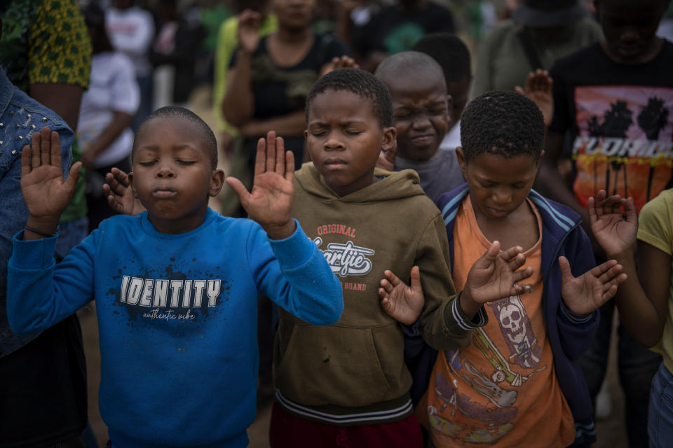 Children pray during an election meeting organized by Ukhonto weSizwe party in Mpumalanga, near Durban, South Africa, Saturday, May 25, 2024, ahead of the 2024 general elections scheduled for May 29. (AP Photo/Emilio Morenatti)