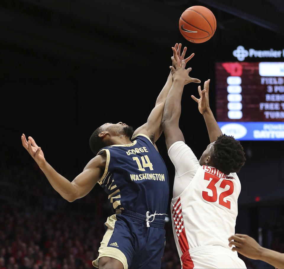 George Washington 's Maceo Jack (14) battles Dayton's Jordy Tshnimanga (32) for a rebound during the first half of an NCAA college basketball game Saturday, March 7, 2020, in Dayton, Ohio. (AP Photo/Tony Tribble)