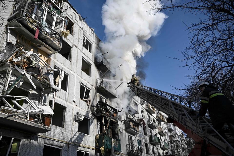 Firefighters work on a fire on a building after bombings on the eastern Ukraine town of Chuguiv on Feb. 24, 2022, as Russian armed forces are trying to invade Ukraine from several directions, using rocket systems and helicopters to attack Ukrainian position in the south, the border guard service said.