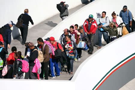 FILE PHOTO: Members of a caravan of migrants from Central America, enter the United States border and customs facility, where they are expected to apply for asylum, in Tijuana, Mexico May 4, 2018. REUTERS/Edgard Garrido/File Photo