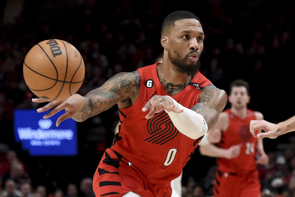 FILE - Portland Trail Blazers guard Damian Lillard, left, passes the ball against the Washington Wizards during the first half of an NBA basketball game in Portland, Ore., Tuesday, Feb. 14, 2023. Lillard is being traded by Portland to play alongside Giannis Antetokounmpo in Milwaukee, a person with knowledge of the agreement said Wednesday, Sept. 27, 2023, a move that ends a three-month saga surrounding his wish to be moved elsewhere with hopes of winning an NBA title and ending his 11-year run with the Trail Blazers.(AP Photo/Steve Dykes, File)