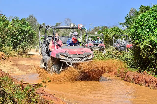 <p>Christine Brown/instagram</p> Christine Brown and David Woolley riding an ATV through the mud.