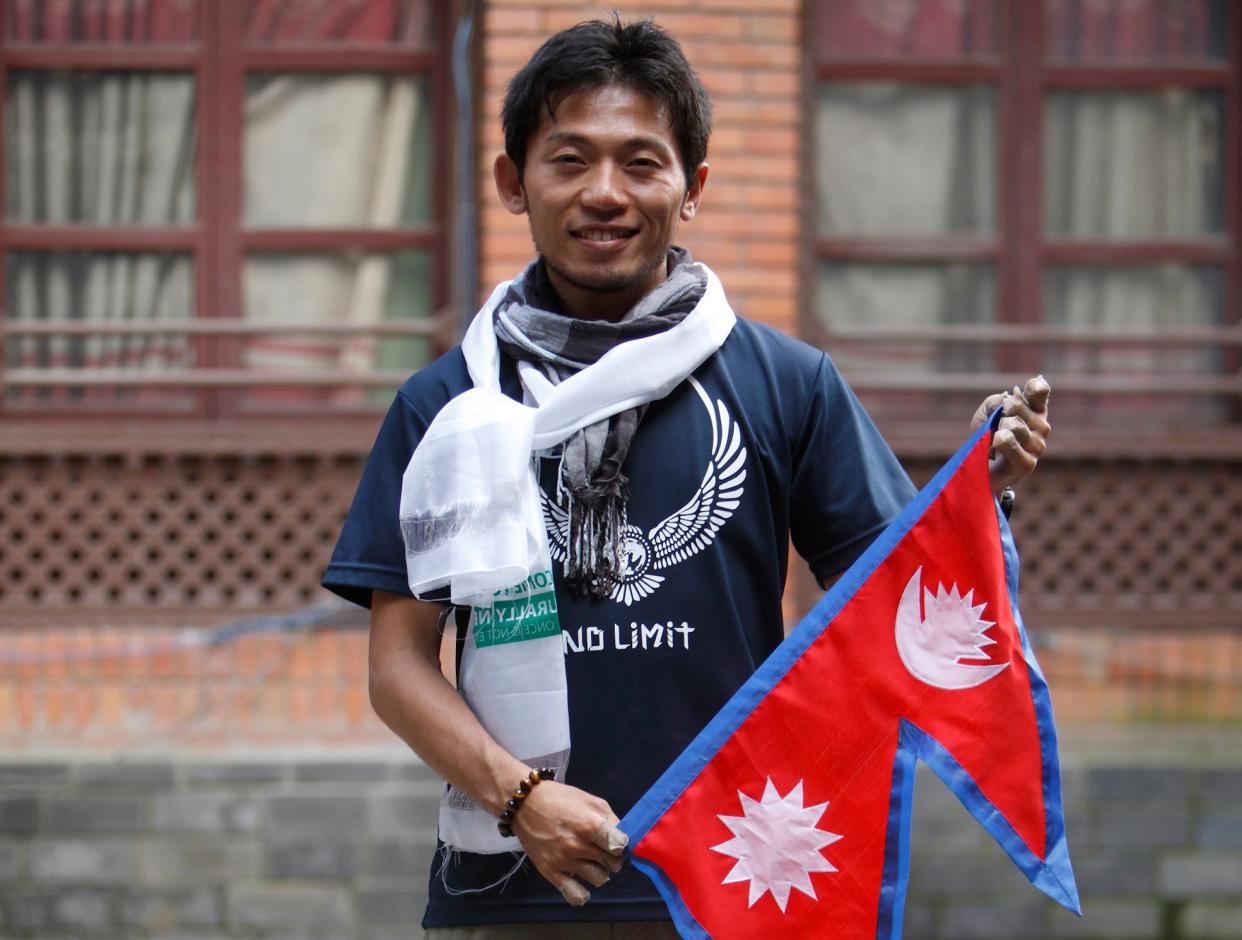 Japanese climber Nobukazu Kuriki poses with a Nepalese flag in 2015: AP