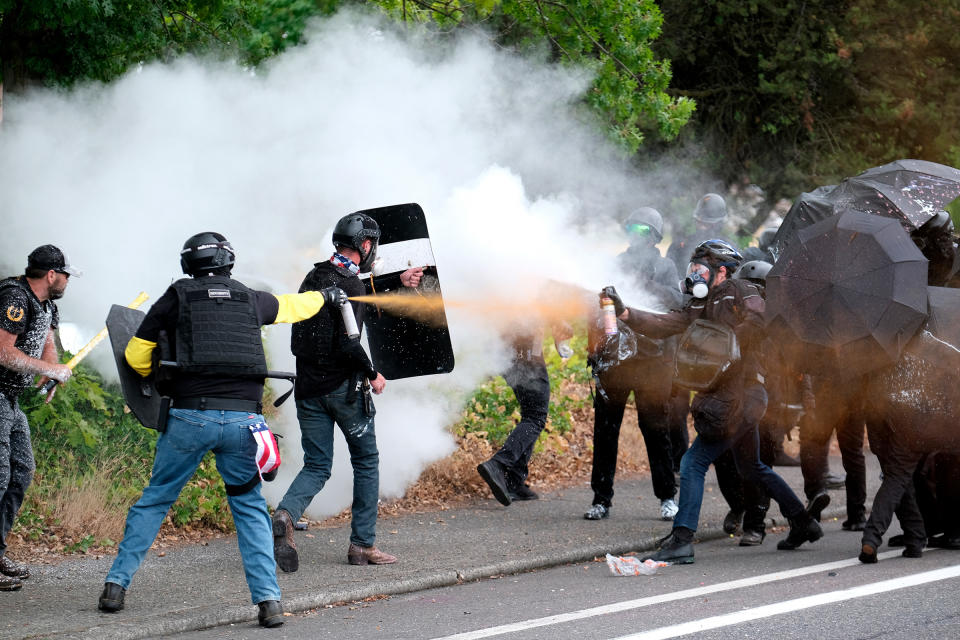 Members of Proud Boys and anti-fascist protesters spray mace at each other during clashes in Portland, Ore., on Aug. 22, 2021.<span class="copyright">Alex Milan Tracy—AP</span>