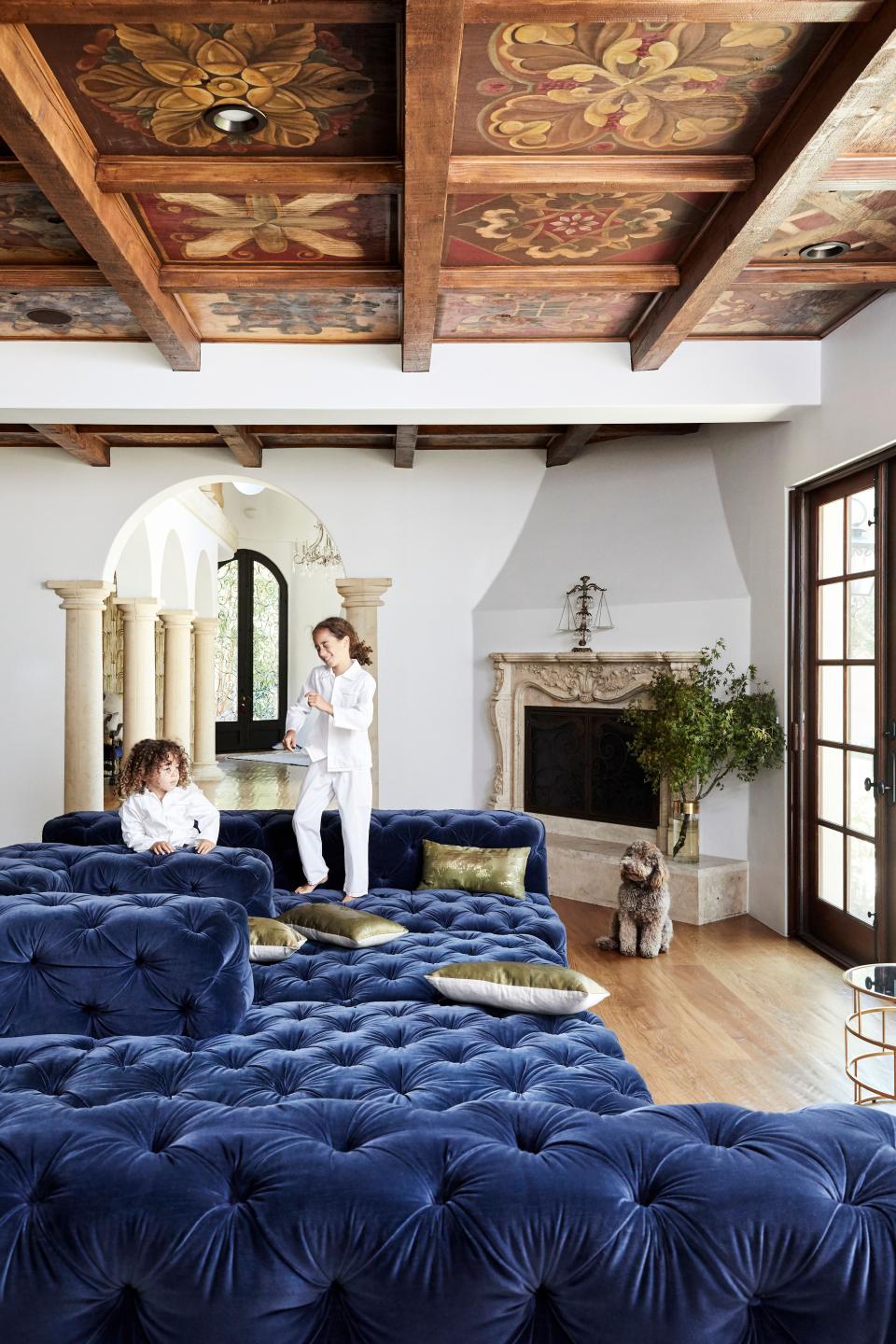 The family area off the kitchen is a favorite place for the children to play. Here, Isaiah (left) and Abraham hang out on the oversized Restoration Hardware couch. The ceiling panels were installed by the previous owners and were hand-painted by local artisans.