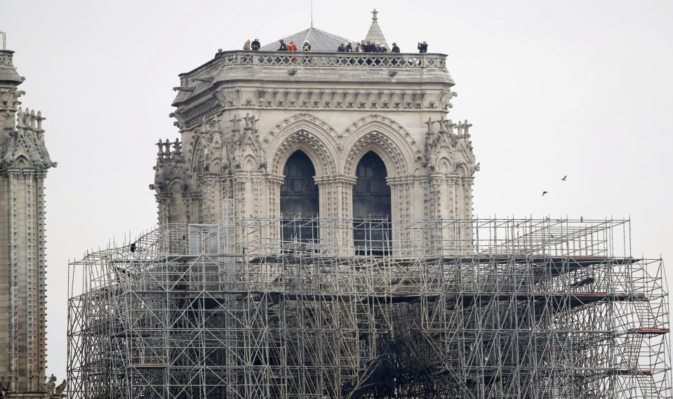 Firemen inspect the Notre Dame cathedral after the fire in Paris, Tuesday, April 16, 2019. Experts are assessing the blackened shell of Paris' iconic Notre Dame cathedral to establish next steps to save what remains after a devastating fire destroyed much of the almost 900-year-old building. With the fire that broke out Monday evening and quickly consumed the cathedral now under control, attention is turning to ensuring the structural integrity of the remaining building. (AP Photo/Christophe Enaa)