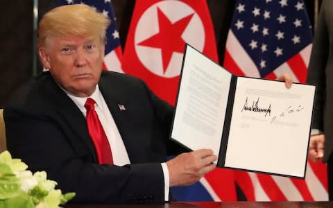 U.S. President Donald Trump shows the document, that he and North Korea's leader Kim Jong Un signed  - Credit: JONATHAN ERNST /Reuters