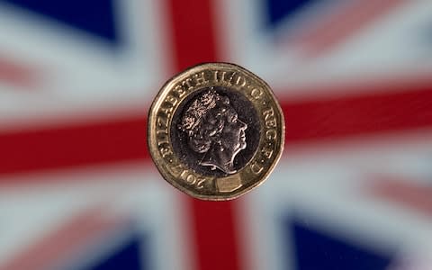 British one pound sterling coin is arranged for a photograph in front of a Union flag - Credit: JUSTIN TALLIS/AFP