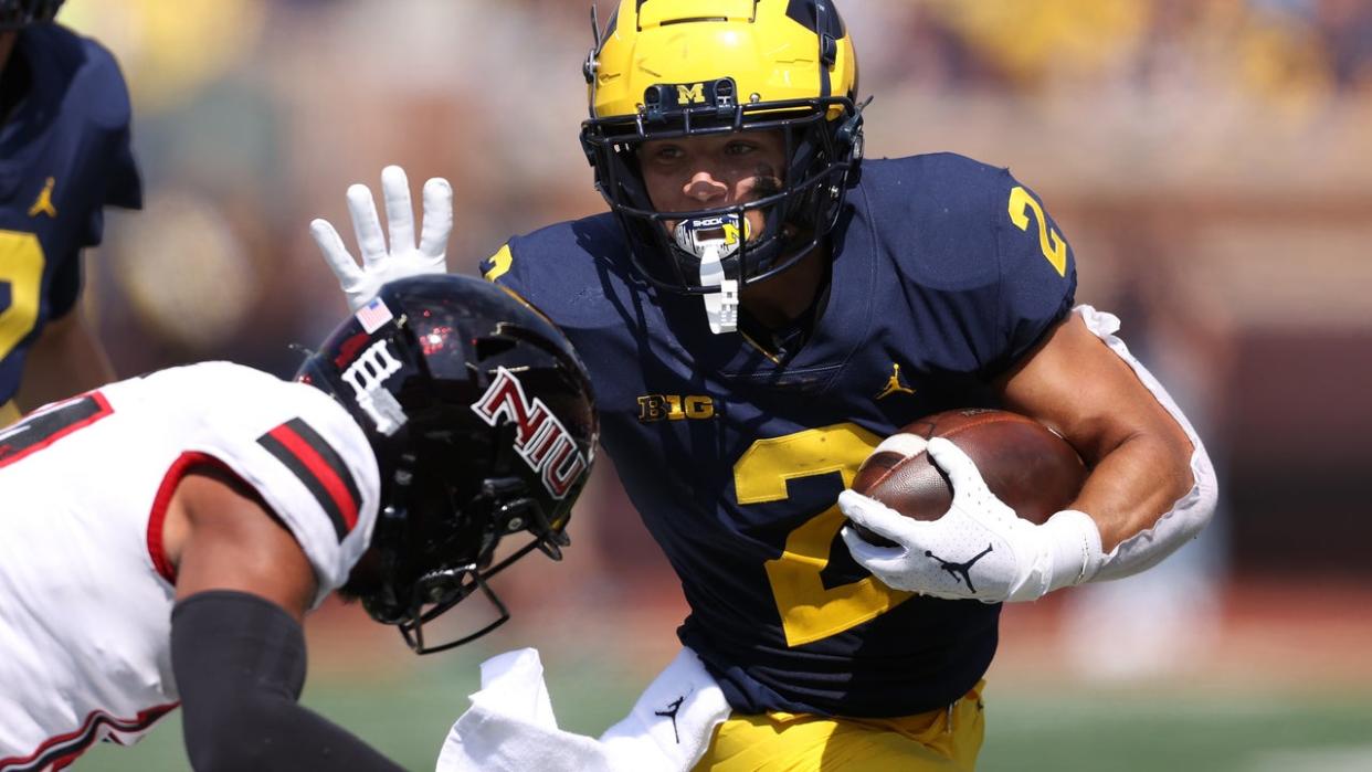 <div>ANN ARBOR, MICHIGAN - SEPTEMBER 18: Blake Corum #2 of the Michigan Wolverines looks to get around the tackle of Eric Rogers #12 of the Northern Illinois Huskies during the first half at Michigan Stadium on September 18, 2021 in Ann Arbor, Michigan. (Photo by Gregory Shamus/Getty Images)</div>