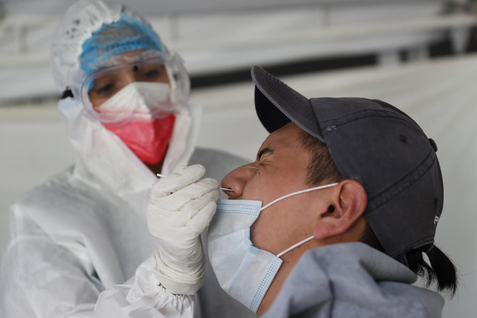 A health worker collects a nasal swab sample for a COVID-19 test in Mexico City, Monday, Aug. 9, 2021. (AP Photo/Marco Ugarte)