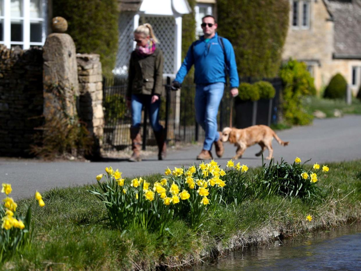 Dog walkers enjoy the sunshine Lower Slaughter, Cotswolds, Gloucestershire, 29 March 2020: David Davies/PA