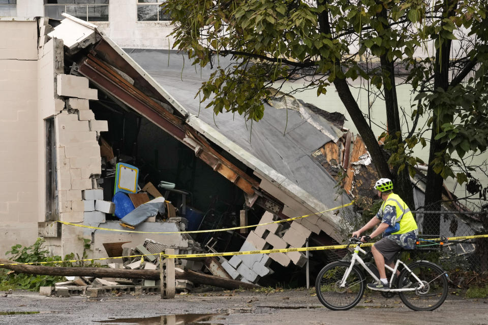 A man views damage to a building caused by recent flooding, Wednesday, Sept. 13, 2023, at the Hilton & Cook Marketplace in Leominster, Mass. (AP Photo/Robert F. Bukaty)