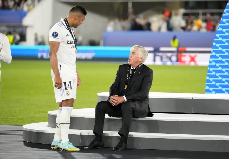 El mediocampista brasileño Casemiro, izquierda, del Real Madrid, conversa con el técnico italiano Carlo Ancelotti después de ganar la final de la Supercopa de la UEFA ante el Eintracht Frankfurt en el Estadio Olímpico de Helsinki, en Finlandia, el miércoles 10 de agosto de 2022. (AP Foto/Sergei Grits)