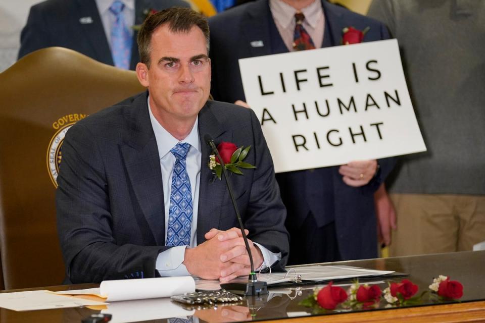 Oklahoma Governor Kevin Stitt is pictured signing legislation making abortion care a felony in April 2022, weeks before the US Supreme Court overturned Roe v Wade (AP)