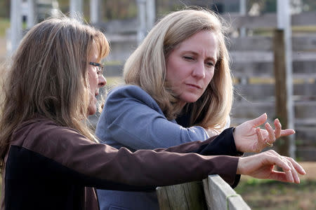 FILE PHOTO: Virginia Democratic candidate for U.S. Representative Abigail Spanberger (R) talks with Jorg Huckabee-Mayfield during a visit to the horse rescue stables she and her husband operate in Burkeville, Virginia, U.S. October 31, 2018. REUTERS/Jonathan Ernst/File Photo