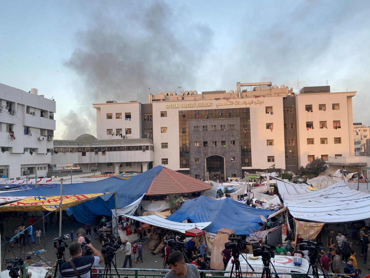 Smoke rises as displaced Palestinians take shelter at Shifa Hospital in Gaza City.