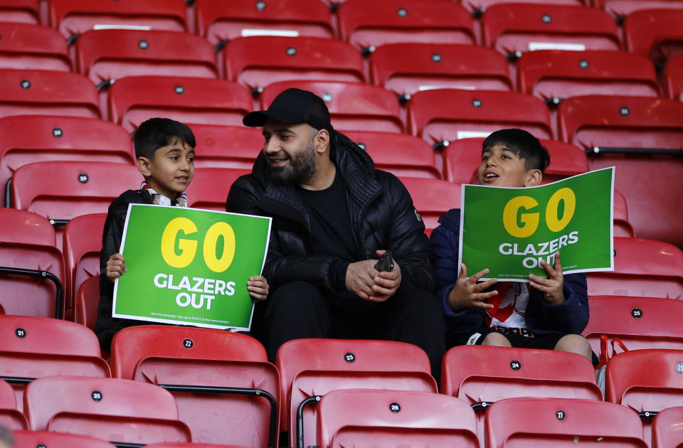 <p>MANCHESTER, ENGLAND - MAY 18: Fans of Manchester United look on from their seat inside of the stadium whilst holding a protest placard ahead of the Premier League match between Manchester United and Fulham at Old Trafford on May 18, 2021 in Manchester, England. A limited number of fans will be allowed into Premier League stadiums as Coronavirus restrictions begin to ease in the UK following the COVID-19 pandemic. (Photo by Phil Noble - Pool/Getty Images)</p>
