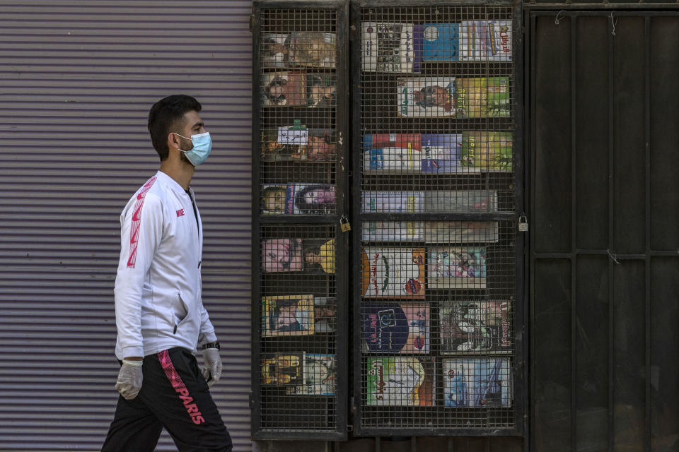 A man wearing a protective mask waalks by closed shops in the Kurdish-majority city of Qamishli in Syria's northeastern Hasakah province, on March 23, 2020, amid measures to curb the spread of the novel coronavirus. - The Kurdish authorities in northeast Syria have not recorded any deaths so far, but have imposed a curfew in a bid to stem any outbreak. (Photo by DELIL SOULEIMAN / AFP) (Photo by DELIL SOULEIMAN/AFP via Getty Images)