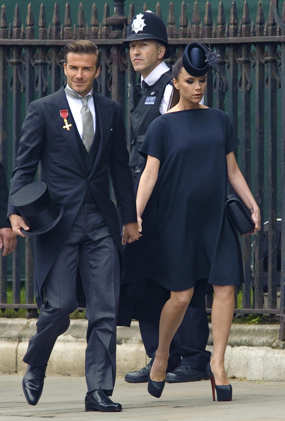 Er trägt einen feinen Anzug, sie ein dunkelblaues Kleid mit Clutch und Hut: David und Victoria Beckham bei der Hochzeit von Prinz William und Kate im April 2011. (AP Photo/Fiona Hanson, Pool)