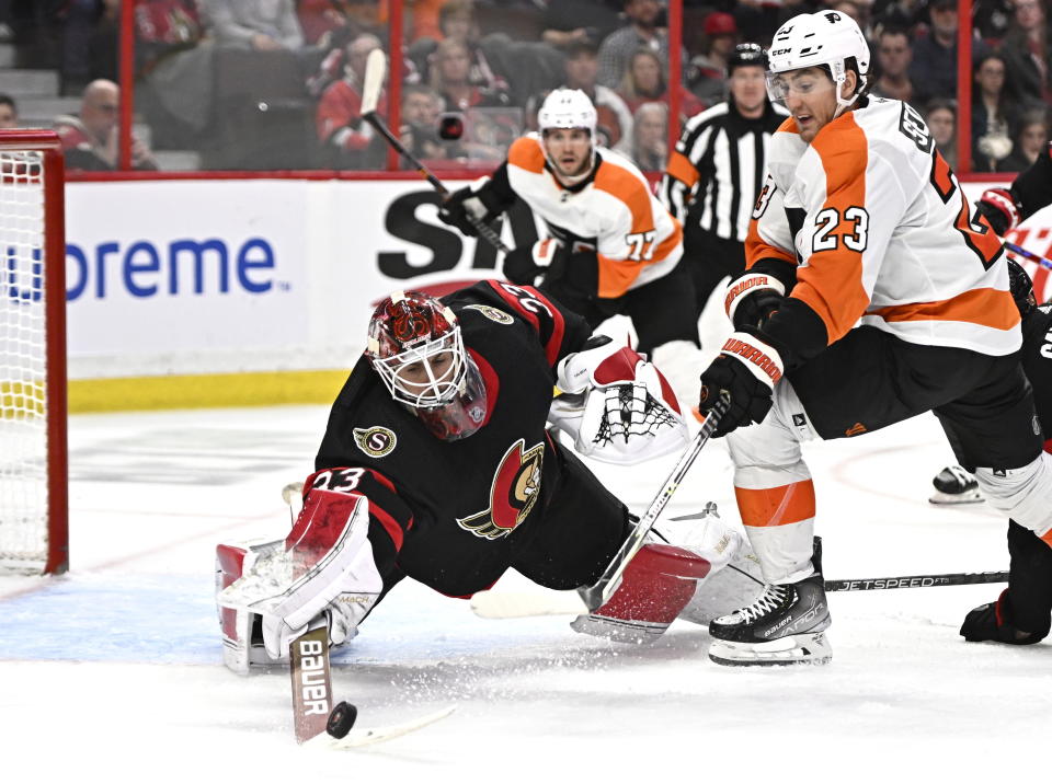 Ottawa Senators goaltender Cam Talbot (33) pokes the puck away from Philadelphia Flyers center Lukas Sedlak (23) during the third period of an NHL hockey game, Saturday, Nov. 5, 2022 in Ottawa, Ontario. (Justin Tang/The Canadian Press via AP)