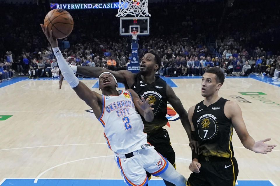 Oklahoma City Thunder guard Shai Gilgeous-Alexander (2) shoots in front of Golden State Warriors forward JaMychal Green, center, and forward Patrick Baldwin Jr. (7) in the first half of an NBA basketball game Tuesday, March 7, 2023, in Oklahoma City. (AP Photo/Sue Ogrocki)