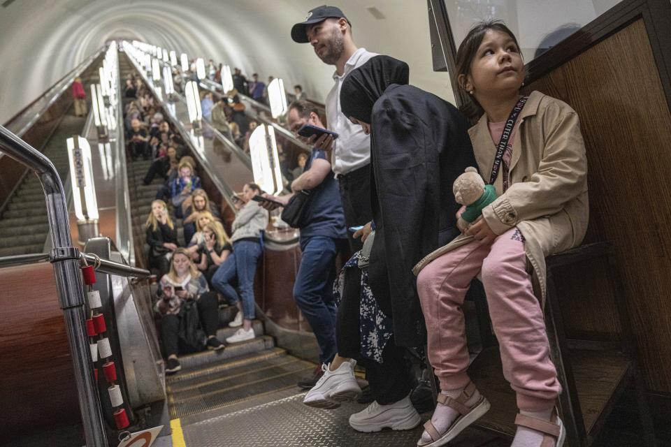 People take cover at metro station during a Russian rocket attack in Kyiv, Ukraine, Monday, May 29, 2023. Explosions have rattled Kyiv during daylight as Russian ballistic missiles fell on the Ukrainian capital. The barrage came hours after a more common nighttime attack of the city by drones and cruise missiles. (AP Photo/Evgeniy Maloletka)