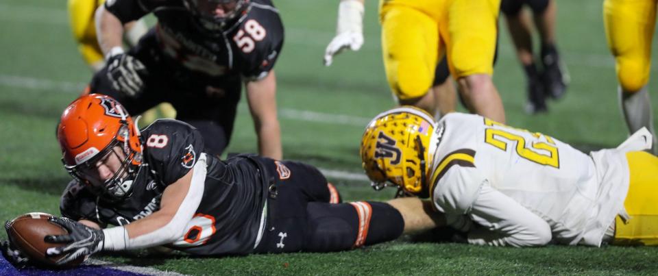 Coldwater's Isaac Fullenkamp reaches the ball over the goal line for a touchdown as he is being brought down by West Jefferson's M.J. Book during the Division VI state semifinal Nov. 27 at Piqua.