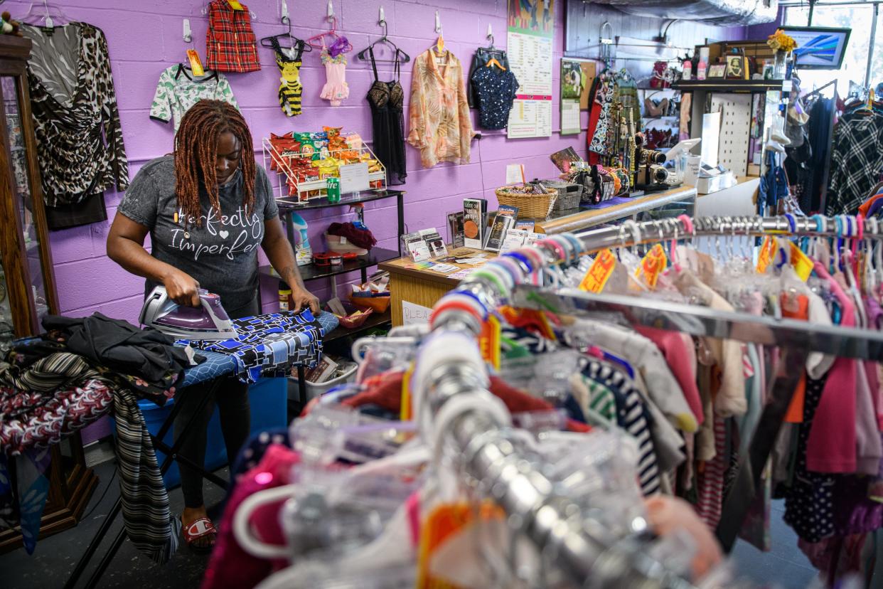 Taleshia Douglas irons some clothing before putting it out on the racks at Shopaholix Consignment and Thrift Store at 2009 Ramsey St.