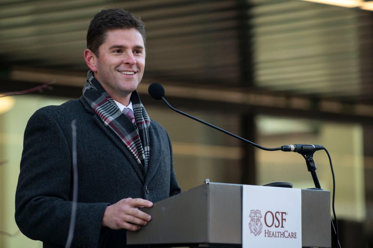 Ryan Spain, Illinois State Rep. and Vice President of Economic Development for OSF, speaks to a crowd outside of the new OSF Healthcare Ministry Headquarters in Downtown Peoria ahead of a ribbon cutting ceremony on Dec. 17, 2021.