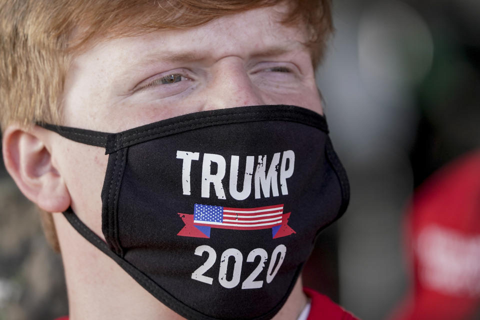 FILE - A supporter wears a "Trump 2020" face mask before a campaign rally with President Donald Trump at the Central Wisconsin Airport, Sept. 17, 2020, in Mosinee, Wis. Andrew Iverson, the director of Trump's 2020 presidential campaign in Wisconsin, who pushed allegations of widespread fraud that were ultimately debunked, has been hired to run the Republican Party of Wisconsin heading into the November 2024 election. (AP Photo/Morry Gash, File)