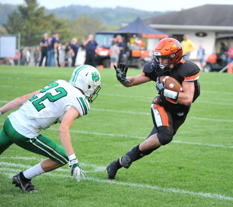 Lucas' Logan Toms delivers a stiff arm during the Cubs' 18-14 loss to Mogadore on Friday night.