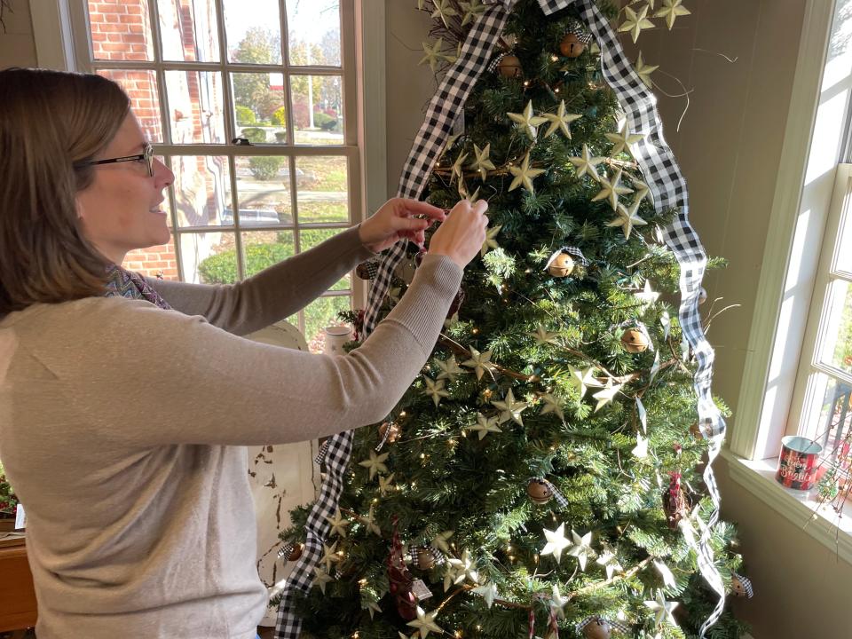 Darcy Green, assistant manager for Brunet Home Design, Decor and Gifts, puts an ornament on the tree Wednesday.