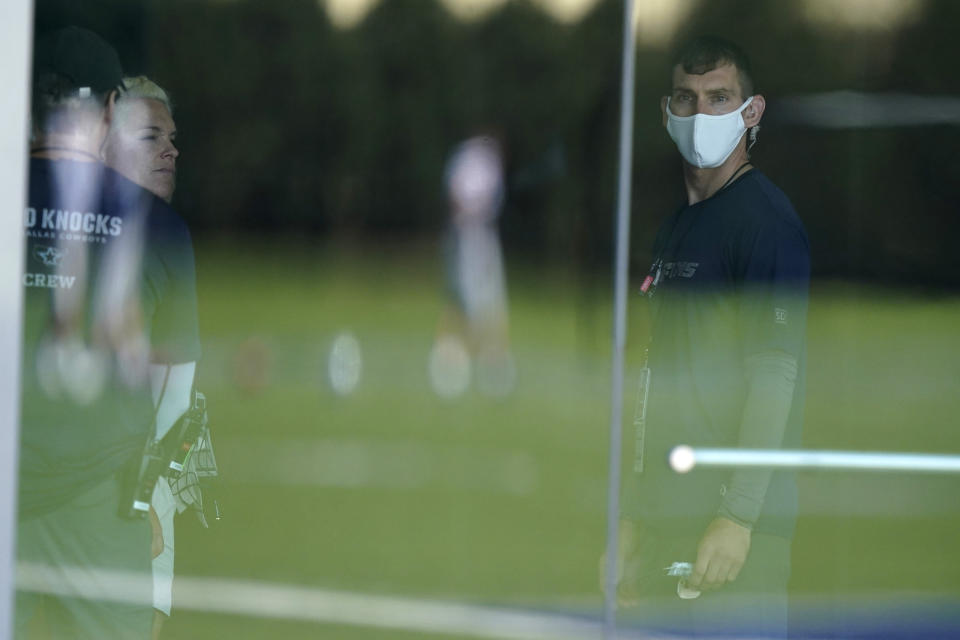 A television crew member looks out onto the Dallas Cowboys practice field during NFL football practice in Frisco, Texas, Tuesday, Aug. 24, 2021. (AP Photo/LM Otero)